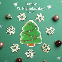Happy St. Nicholas day, greeting card design. Tasty cookie in shape of Christmas tree and decorations on green background, flat lay