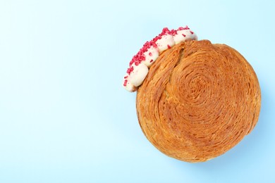 One supreme croissant with cream on light blue background, top view with space for text. Tasty puff pastry