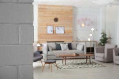 Photo of White brick wall and blurred living room interior on background