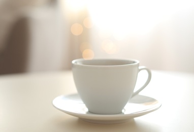 Photo of Cup of aromatic coffee on table indoors. Bokeh effect