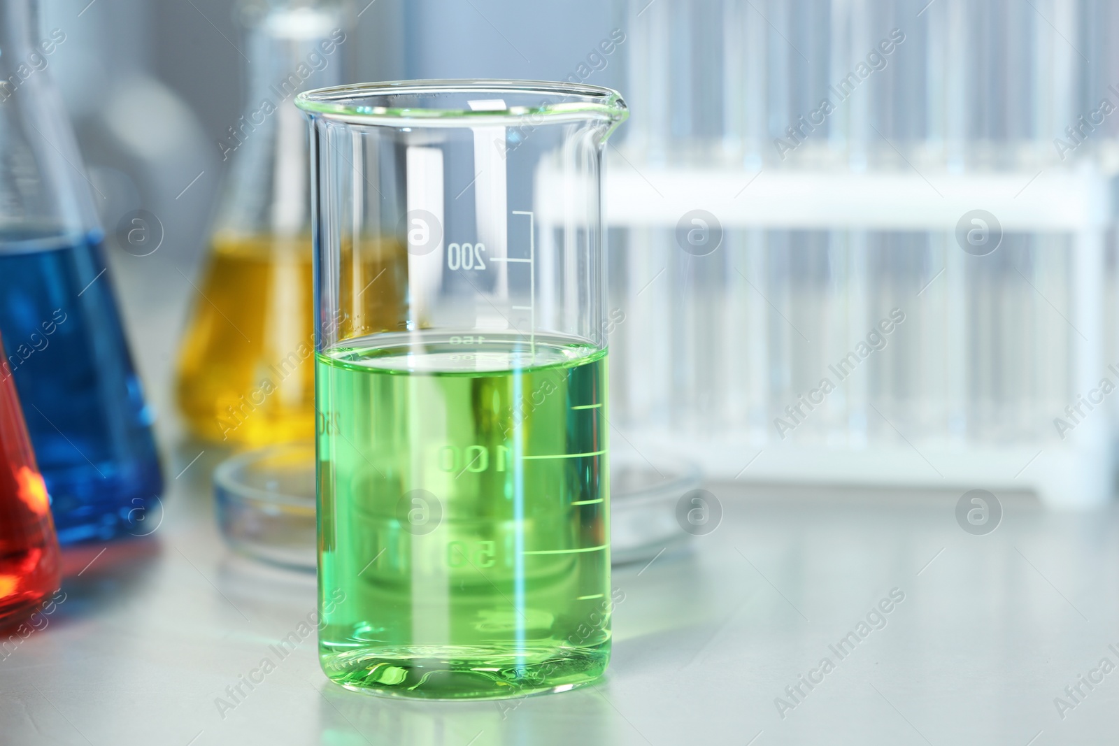 Photo of Beaker with colorful liquid on table in laboratory