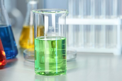 Beaker with colorful liquid on table in laboratory