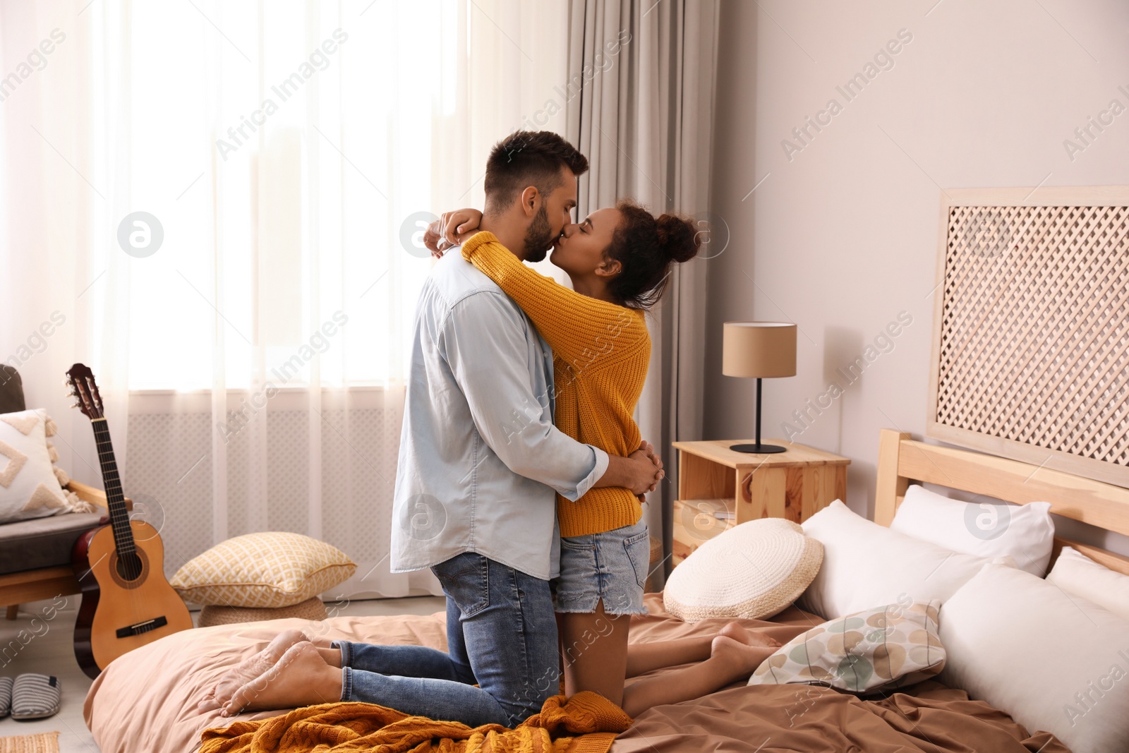 Photo of Lovely couple enjoying each other on bed at home