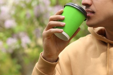 Man with takeaway coffee cup in park, closeup