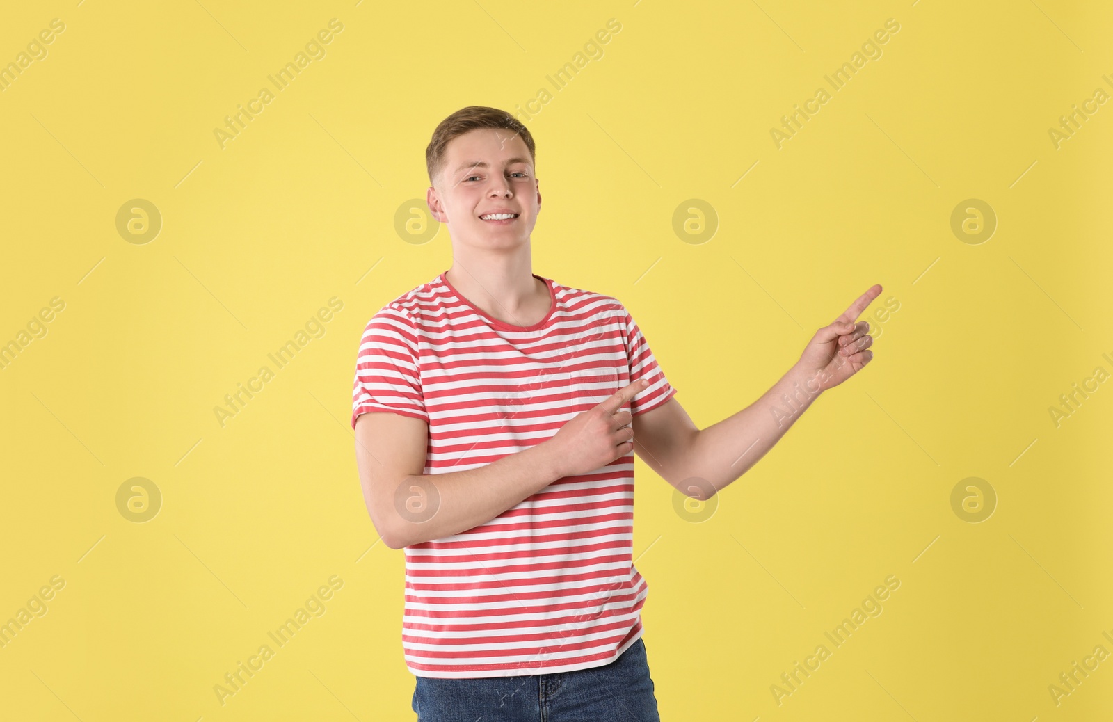 Photo of Portrait of teenage boy on yellow background