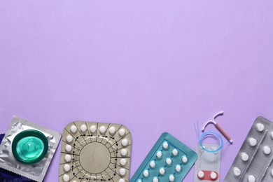 Photo of Contraceptive pills, condoms and intrauterine device on color background, flat lay with space for text. Different birth control methods