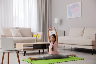 Cute little girl taking online dance class at home