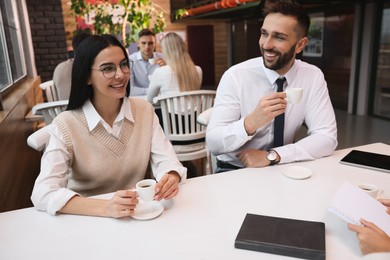 Photo of Coworkers enjoying coffee during break in cafe