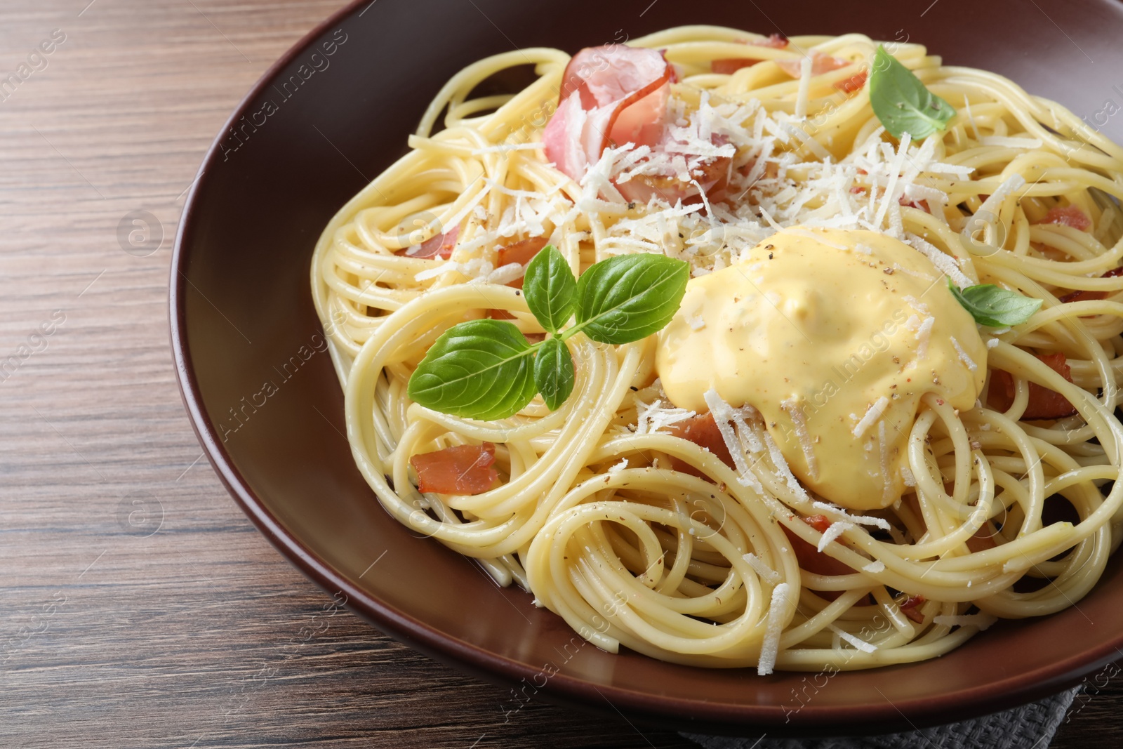 Photo of Delicious spaghetti with cheese sauce and meat on wooden table, closeup