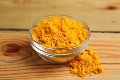 Aromatic saffron powder in bowl on wooden table