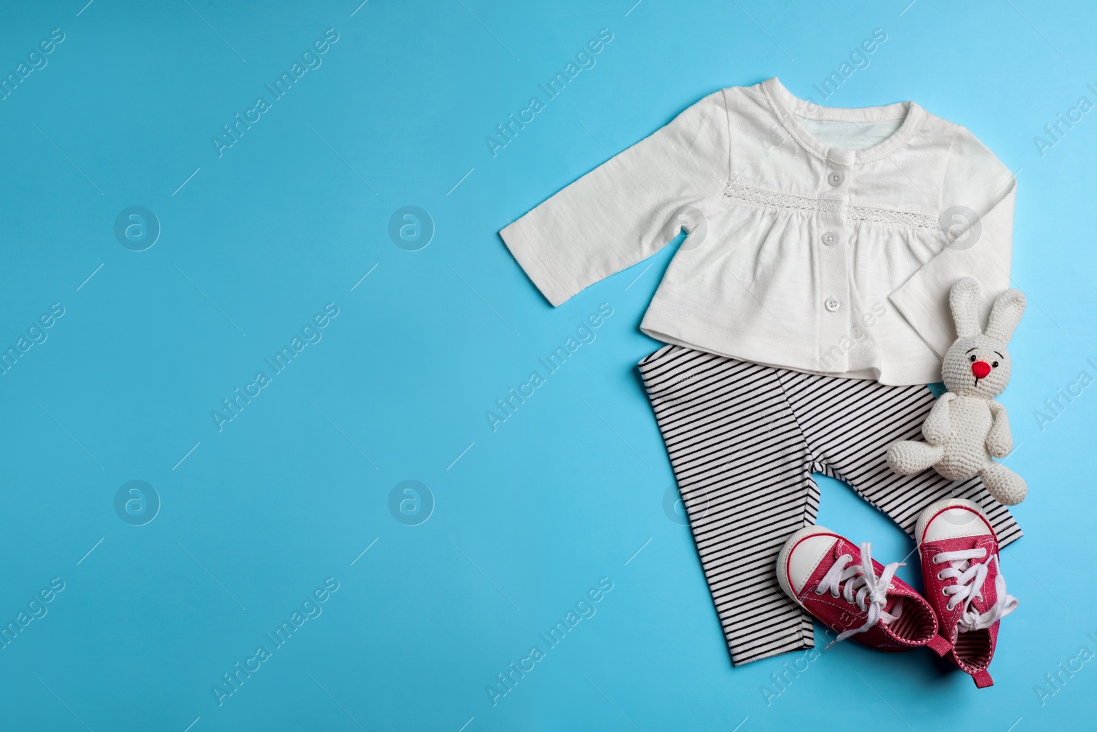 Photo of Flat lay composition with clothes and space for text on color background. Baby accessories