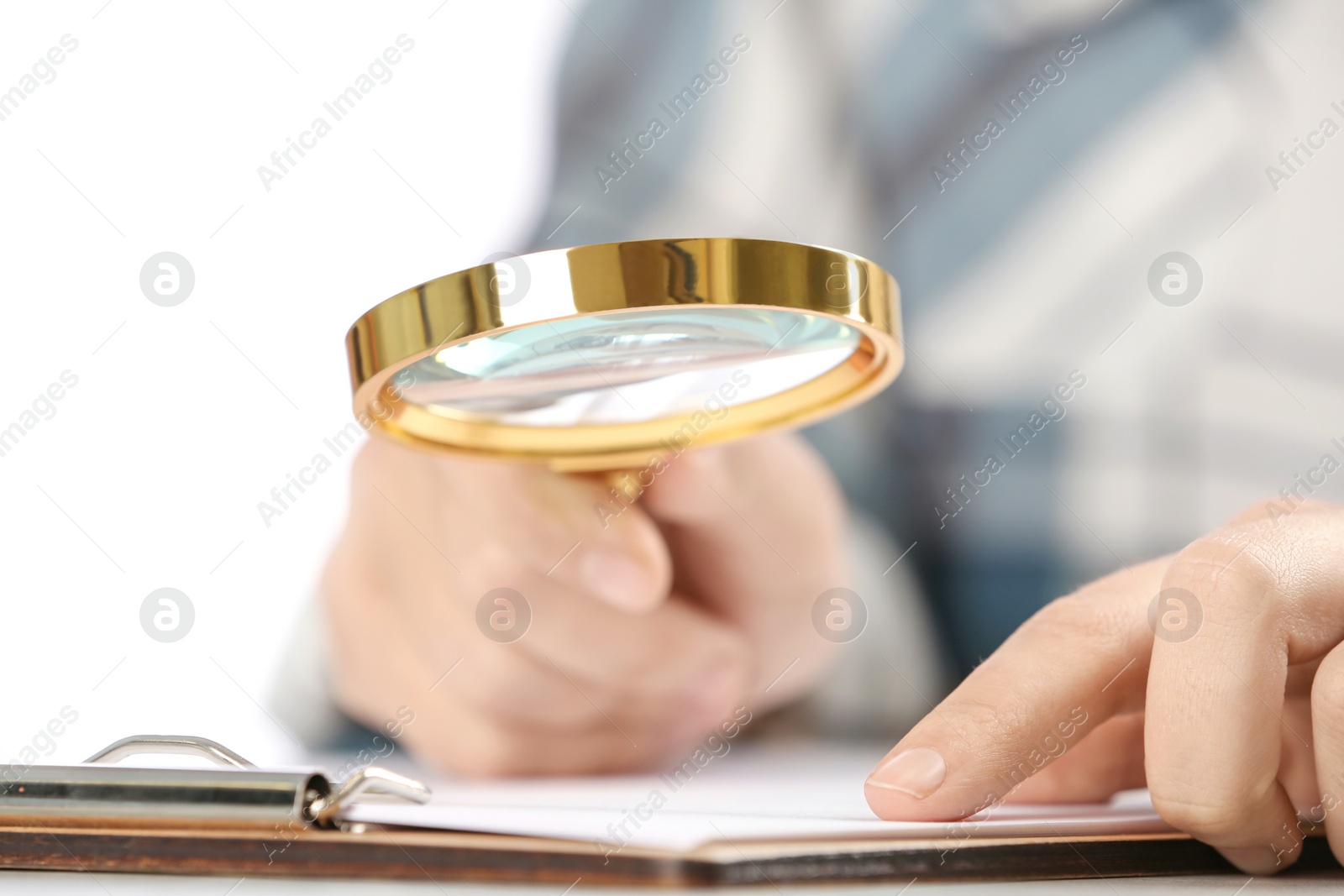 Photo of Woman using magnifying glass at table, closeup