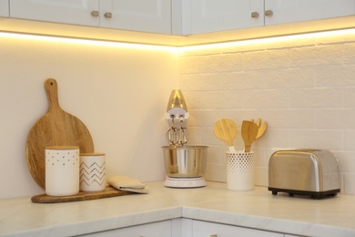 Modern toaster, mixer and utensils on counter in kitchen