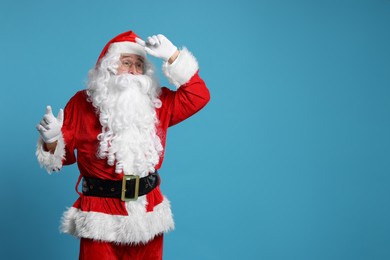Photo of Merry Christmas. Santa Claus posing on light blue background, space for text