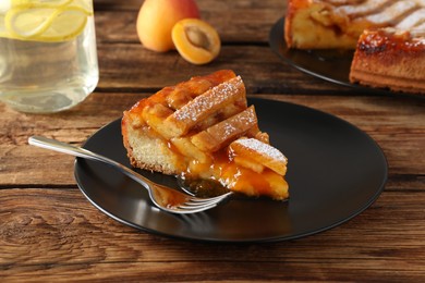 Photo of Piece of tasty apricot pie on wooden table