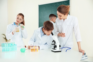 Teacher and pupils at chemistry lesson in classroom