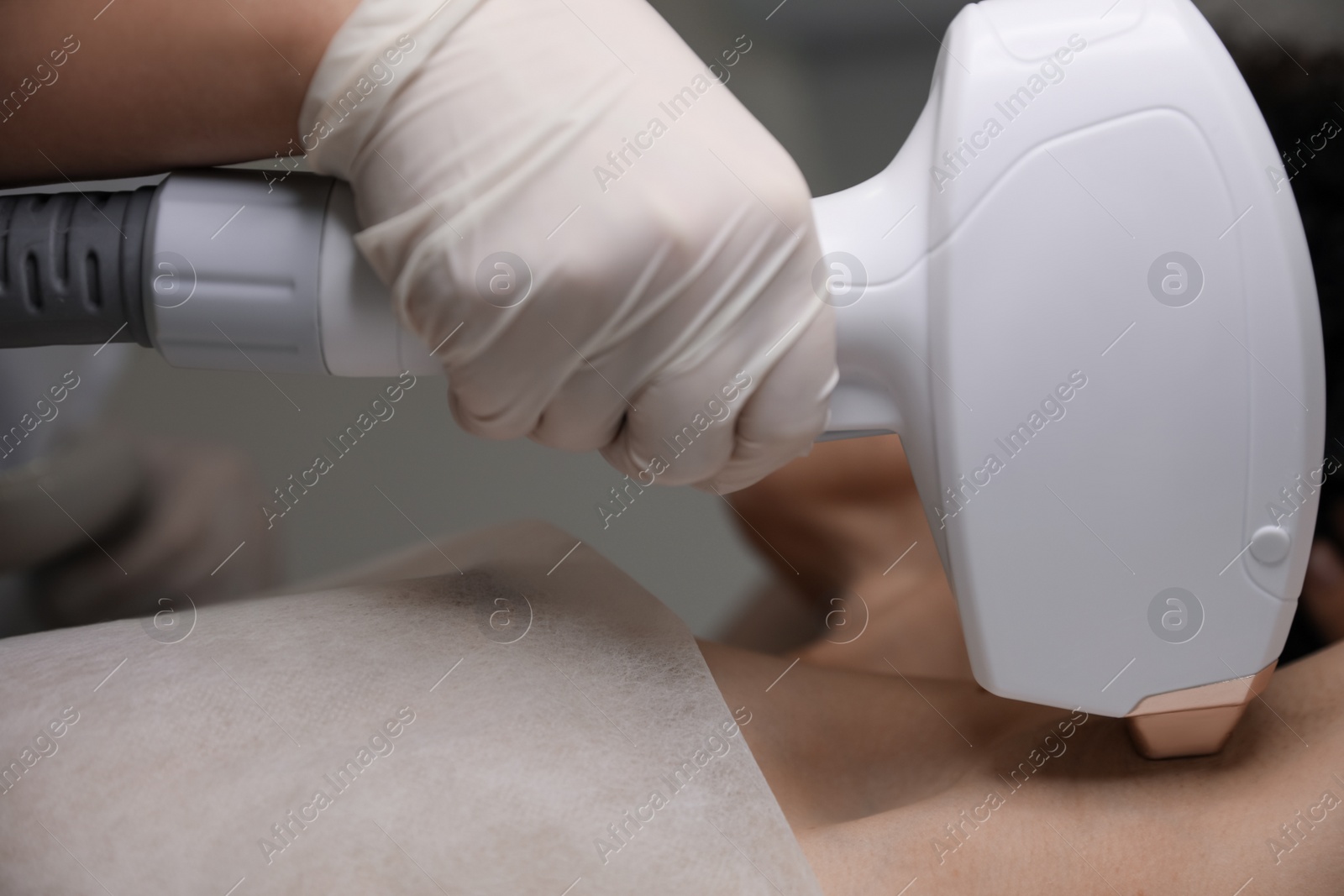 Photo of Woman undergoing laser epilation procedure, closeup view