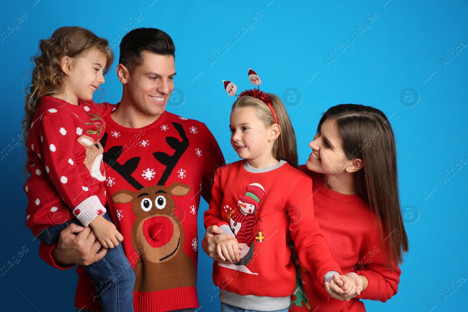 Photo of Family in Christmas sweaters on blue background