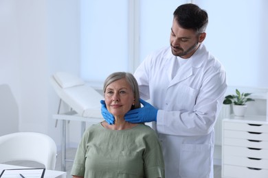 Photo of Endocrinologist examining thyroid gland of patient at hospital