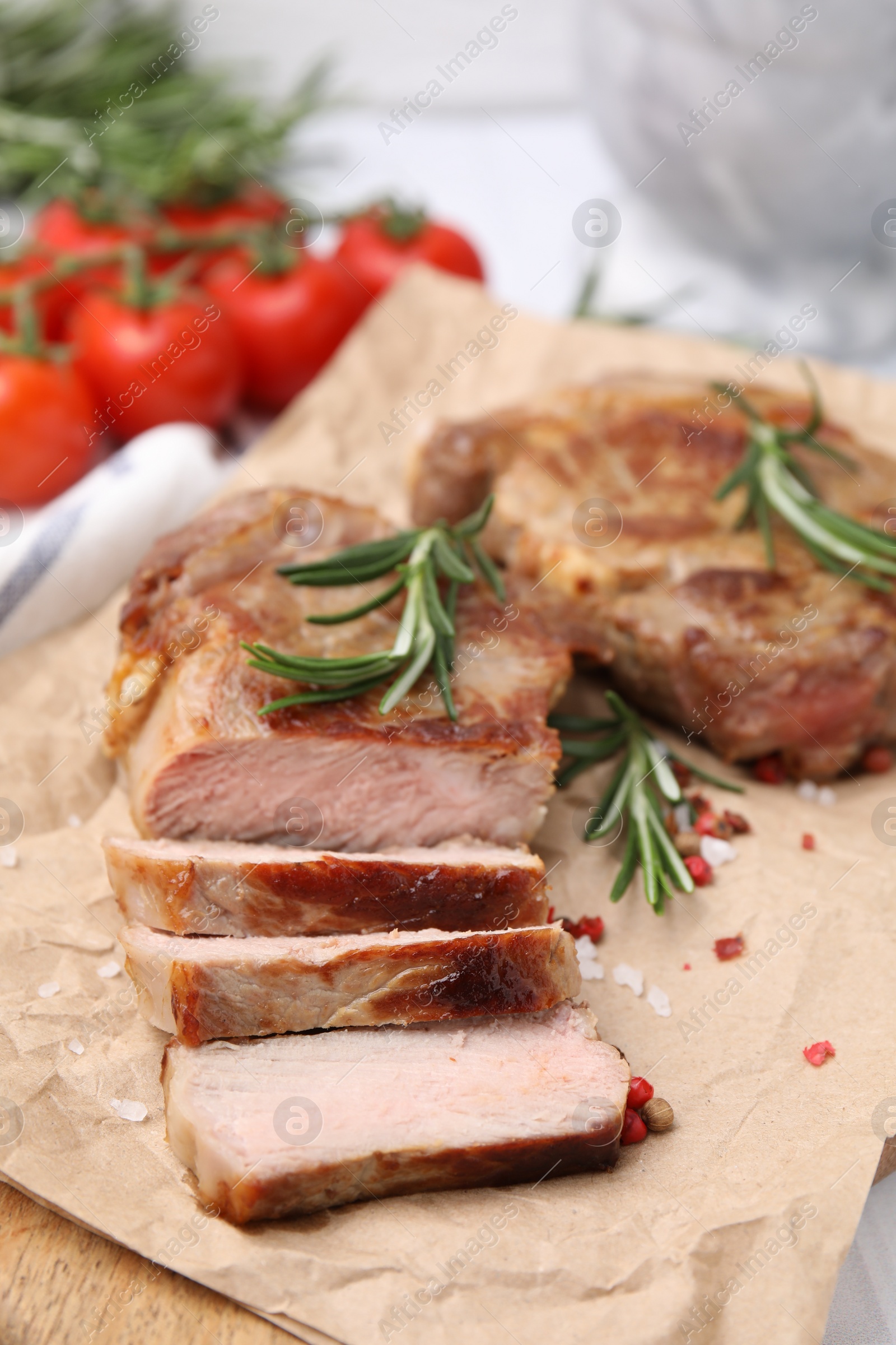 Photo of Delicious fried meat with rosemary and spices on wooden board, closeup