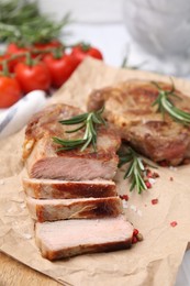 Delicious fried meat with rosemary and spices on wooden board, closeup