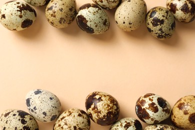 Photo of Many speckled quail eggs on beige background, flat lay. Space for text