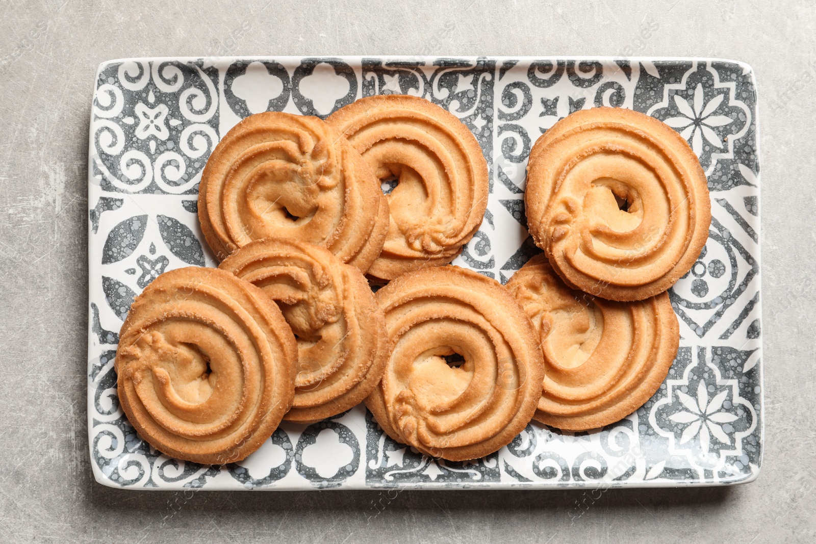 Photo of Plate with Danish butter cookies on grey background, top view