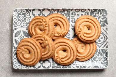 Plate with Danish butter cookies on grey background, top view