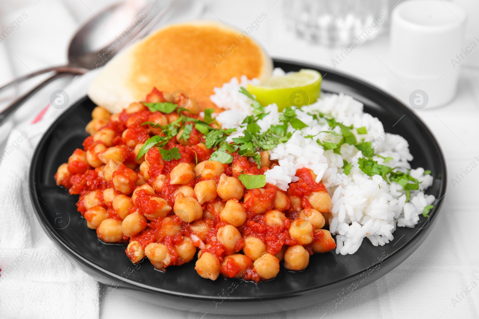 Photo of Delicious chickpea curry with rice on table, closeup