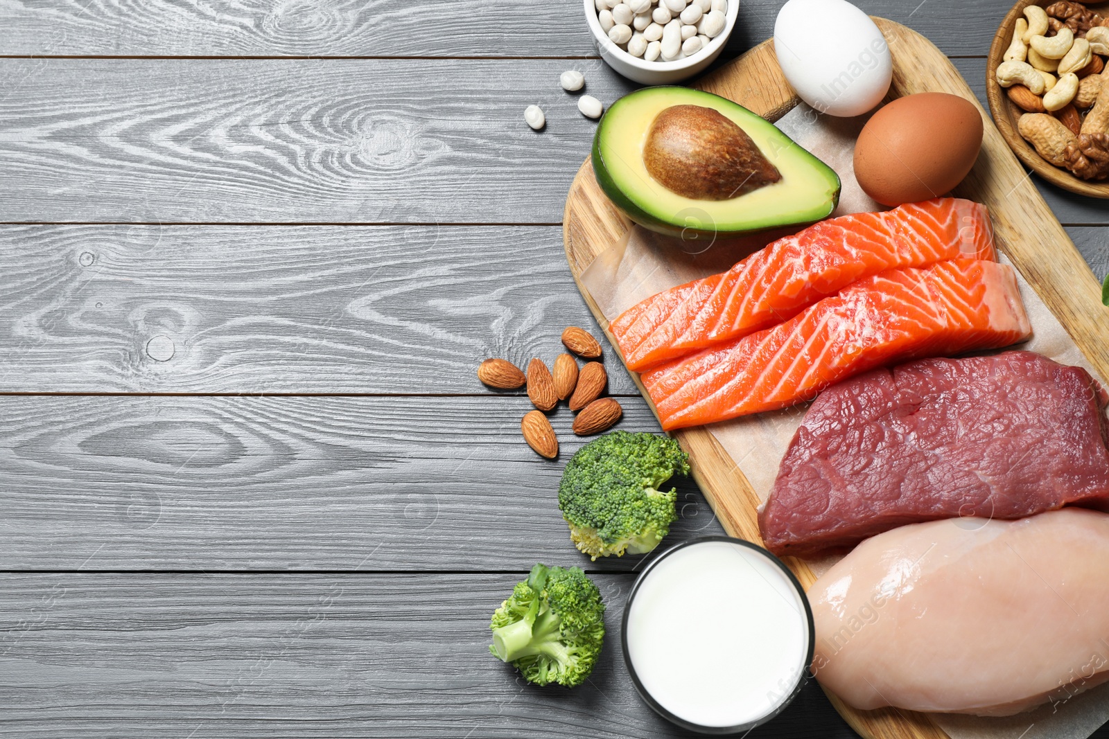 Photo of Products rich in protein on grey wooden table, above view. Space for text