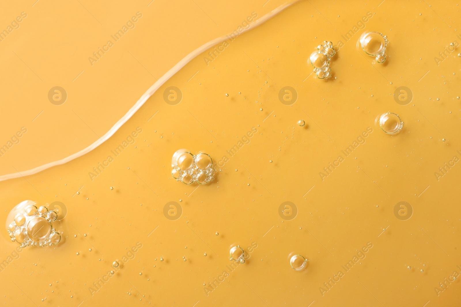 Photo of Sample of hydrophilic oil on orange background, top view