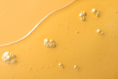 Photo of Sample of hydrophilic oil on orange background, top view