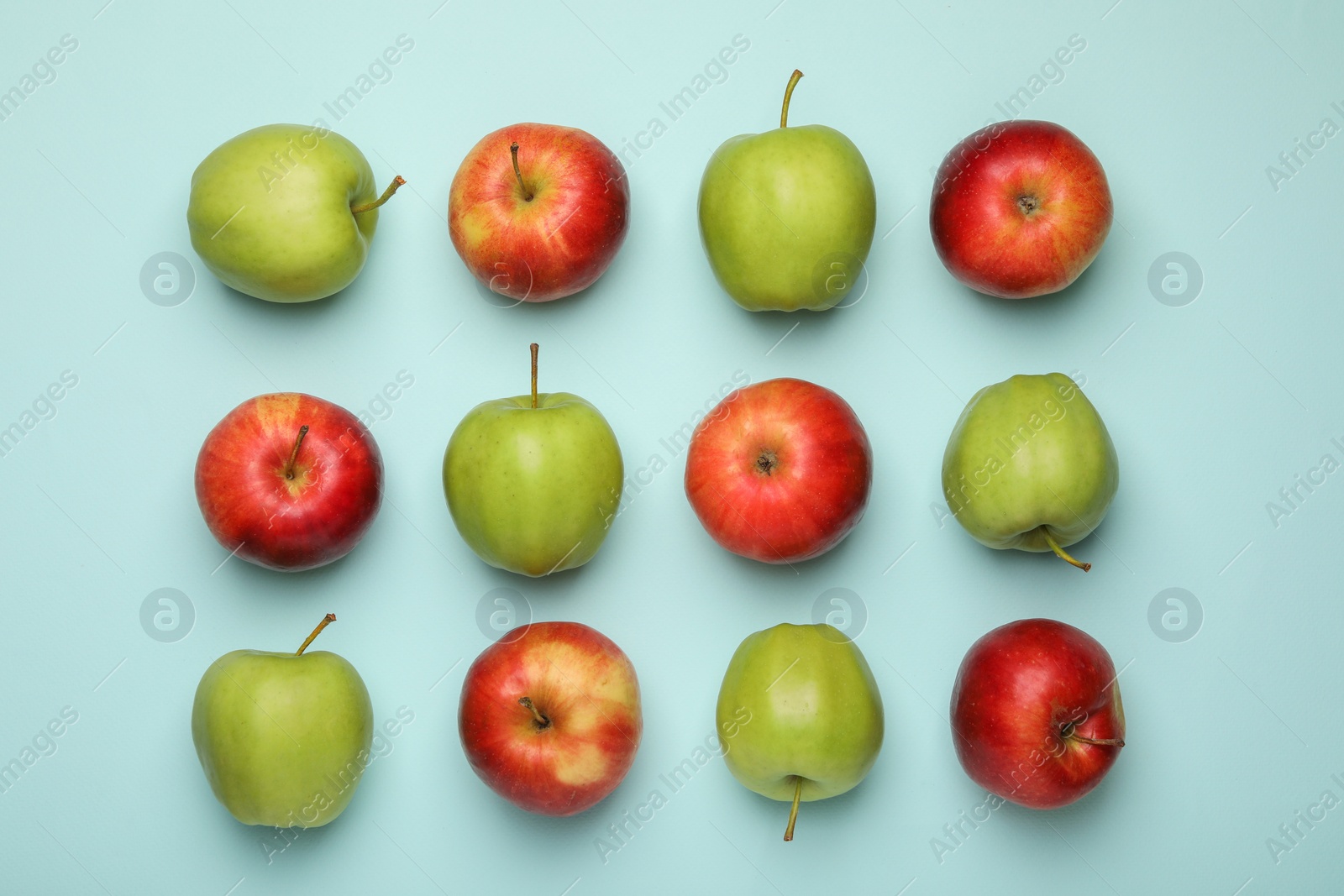 Photo of Fresh colorful apples on light blue background, flat lay