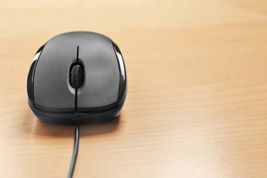 Modern computer mouse on wooden background