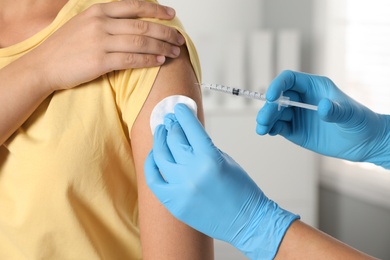 Doctor giving injection to patient in hospital, closeup. Vaccination day