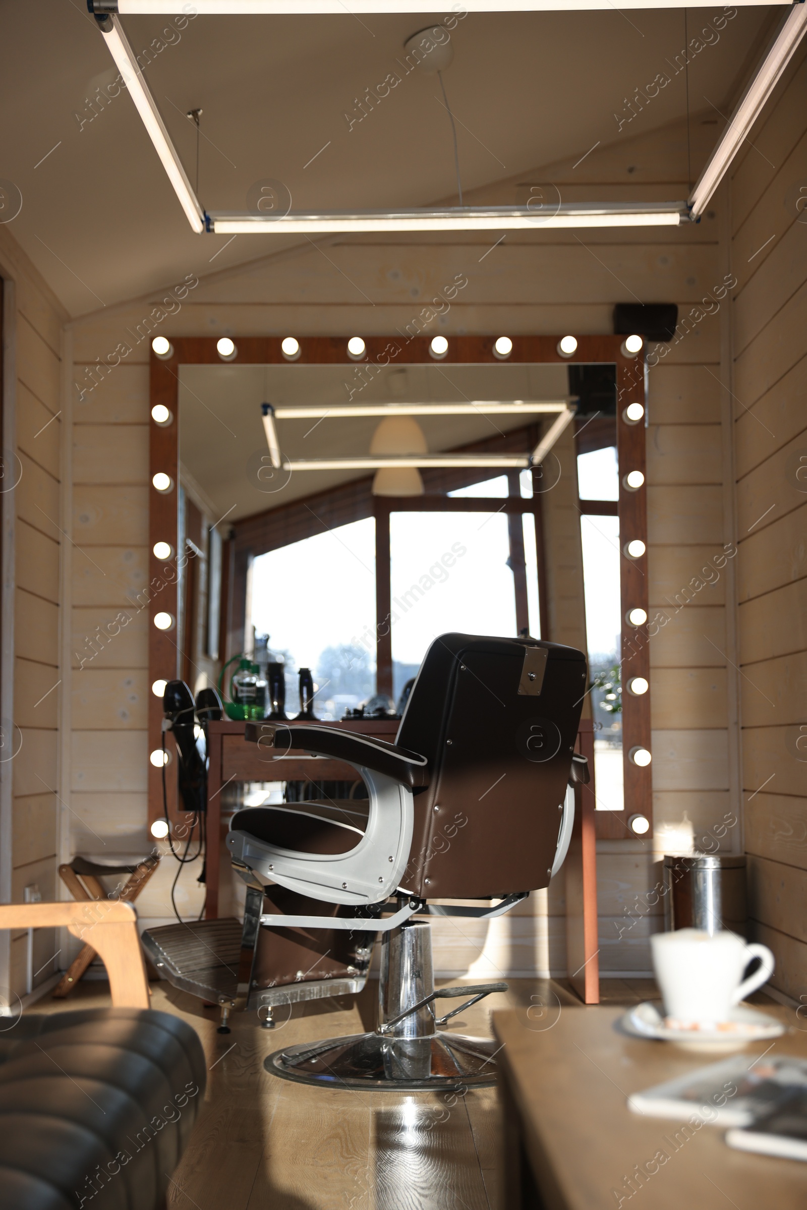 Photo of Stylish hairdresser's workplace with professional armchair in barbershop