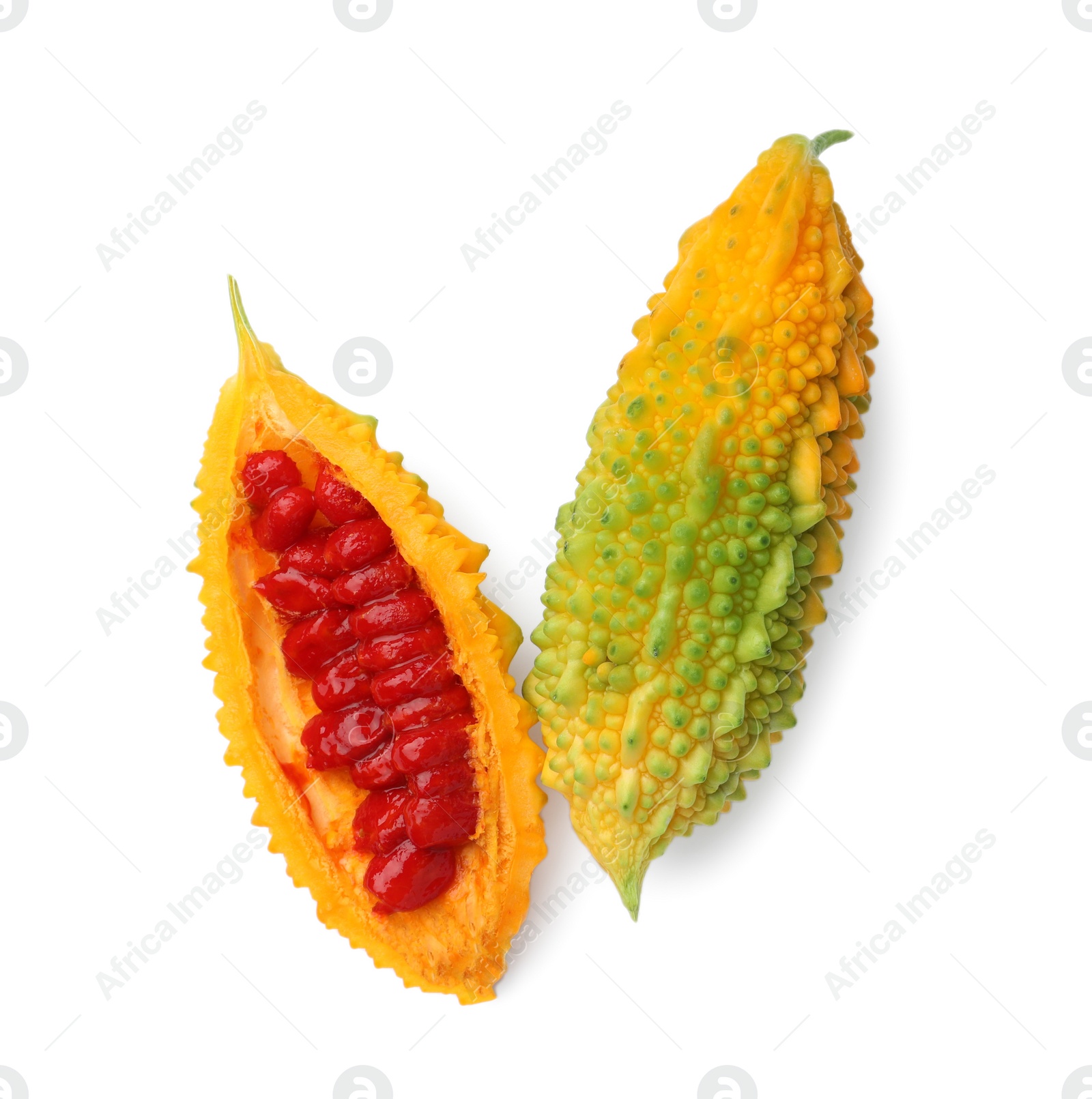 Photo of Whole and cut ripe bitter melons on white background, top view