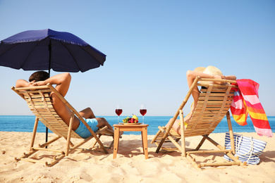 Photo of Couple resting on sunny beach at resort