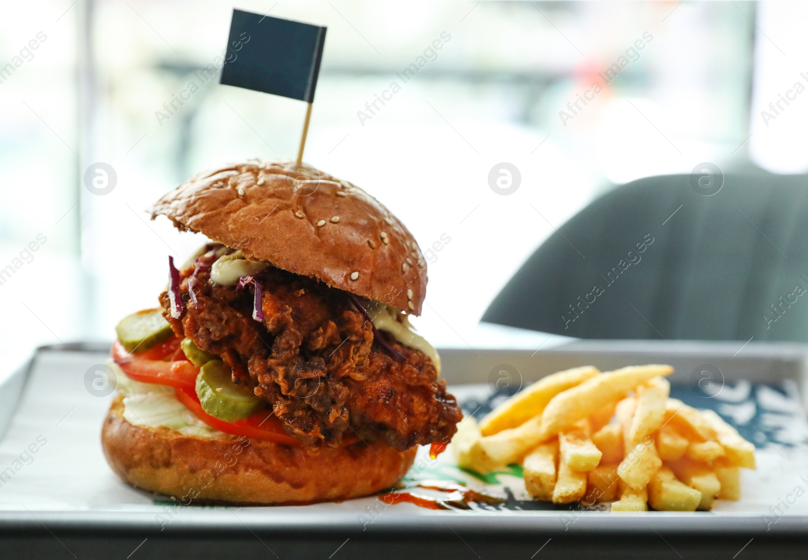 Photo of Tray with delicious burger and french fries on blurred background