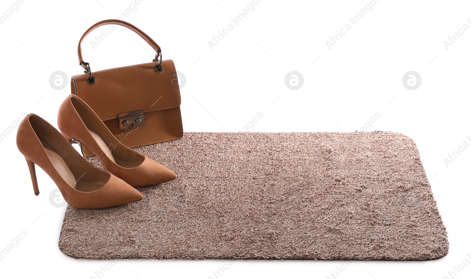 Photo of Stylish door mat with high heeled shoes and bag on white background