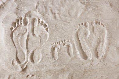 Photo of Family footprints on sandy beach, top view
