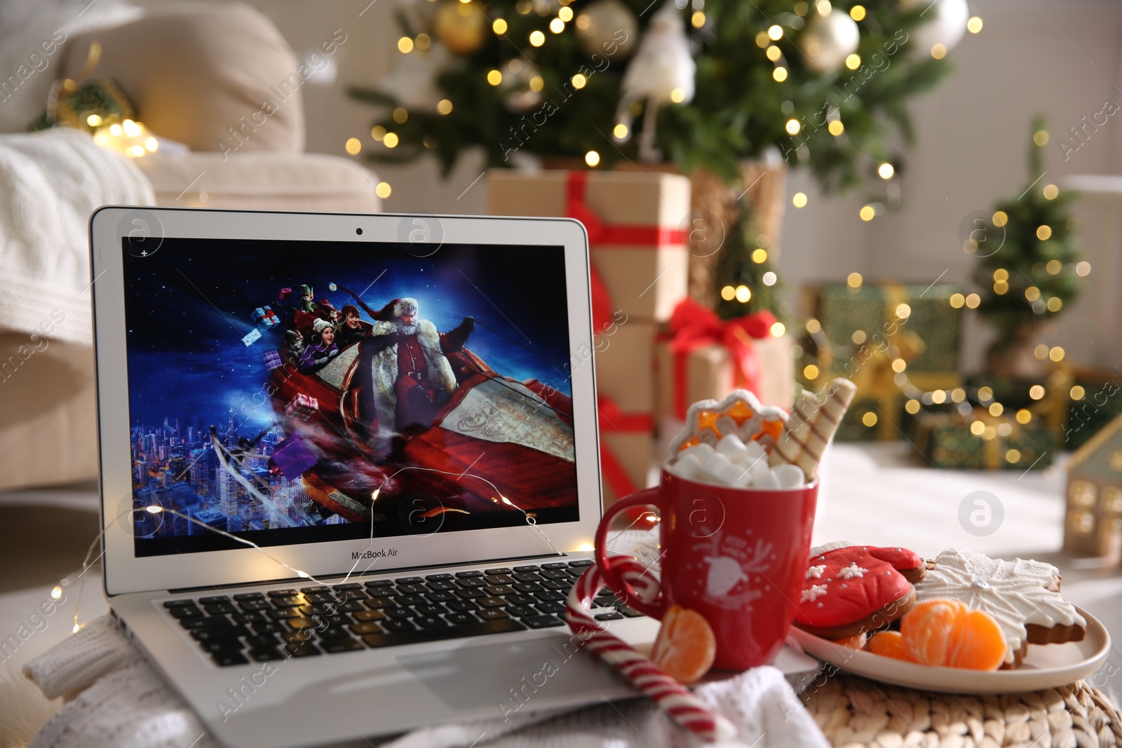 Photo of MYKOLAIV, UKRAINE - DECEMBER 25, 2020: Laptop displaying Christmas Chronicles movie at home. Cozy winter holidays atmosphere