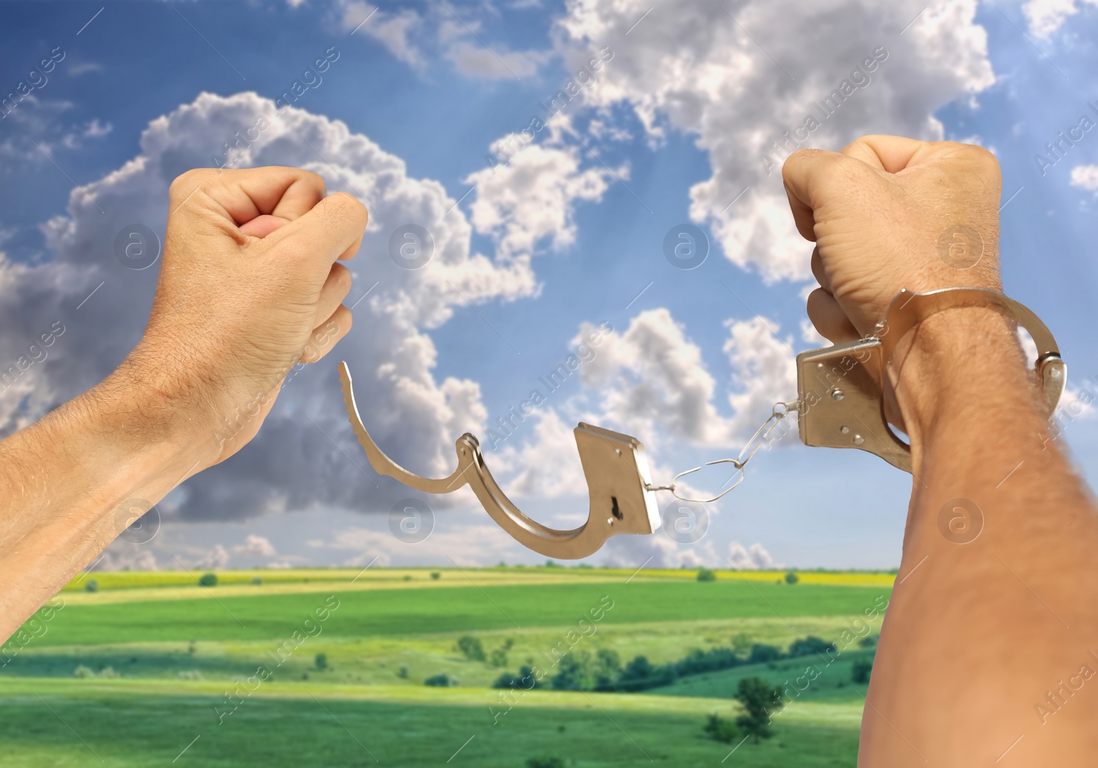 Image of Freedom. Man with handcuffs on his hand outdoors, closeup