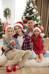 Photo of Happy family with cute children near Christmas tree together at home