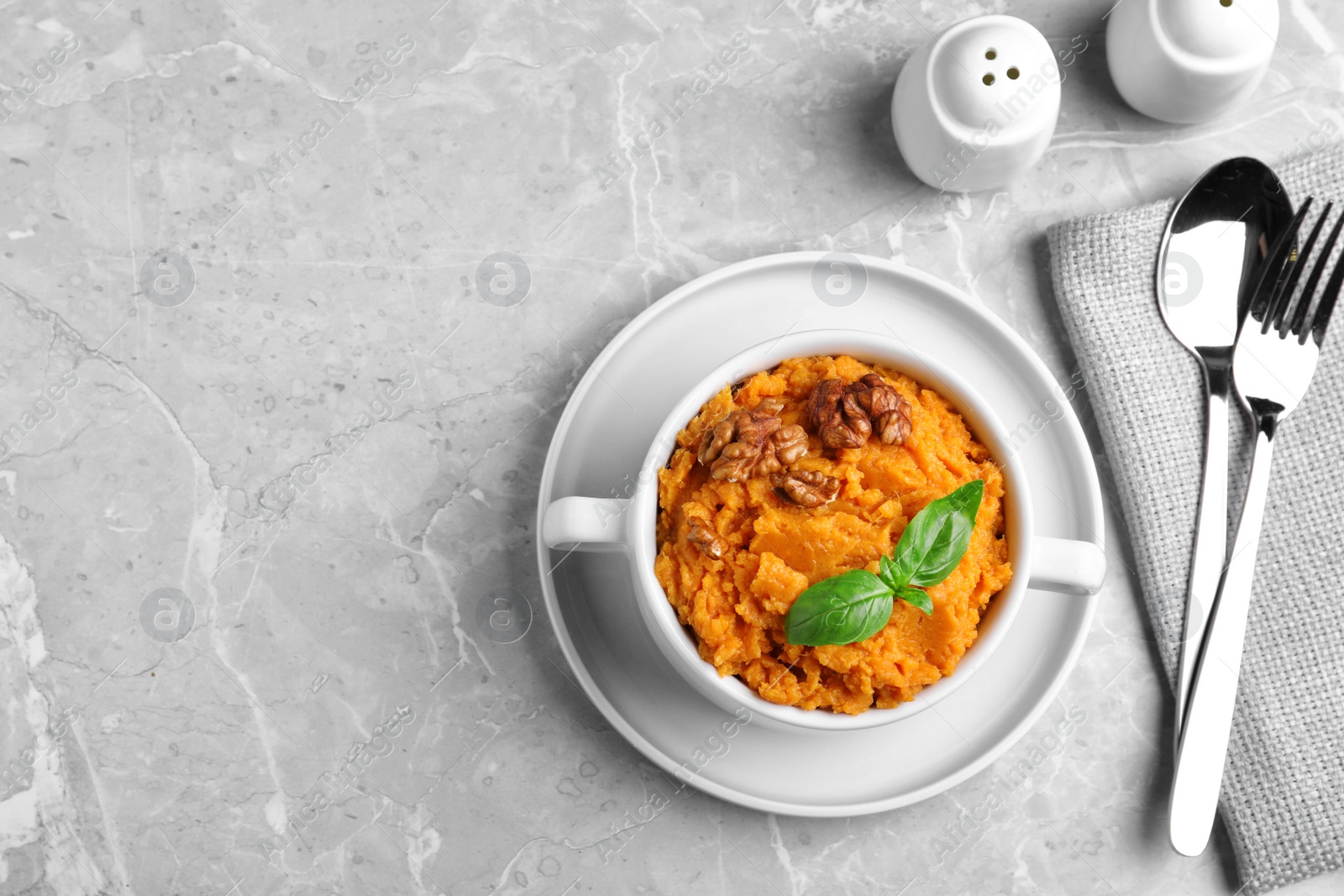 Photo of Tasty sweet potato puree served on grey marble table, top view. Space for text