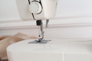 Photo of Sewing machine near white wall, closeup view