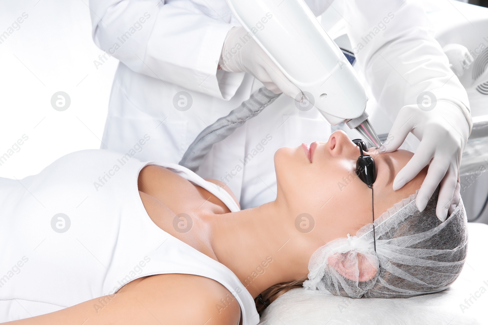 Photo of Young woman undergoing laser removal of permanent makeup in salon. Eyebrow correction