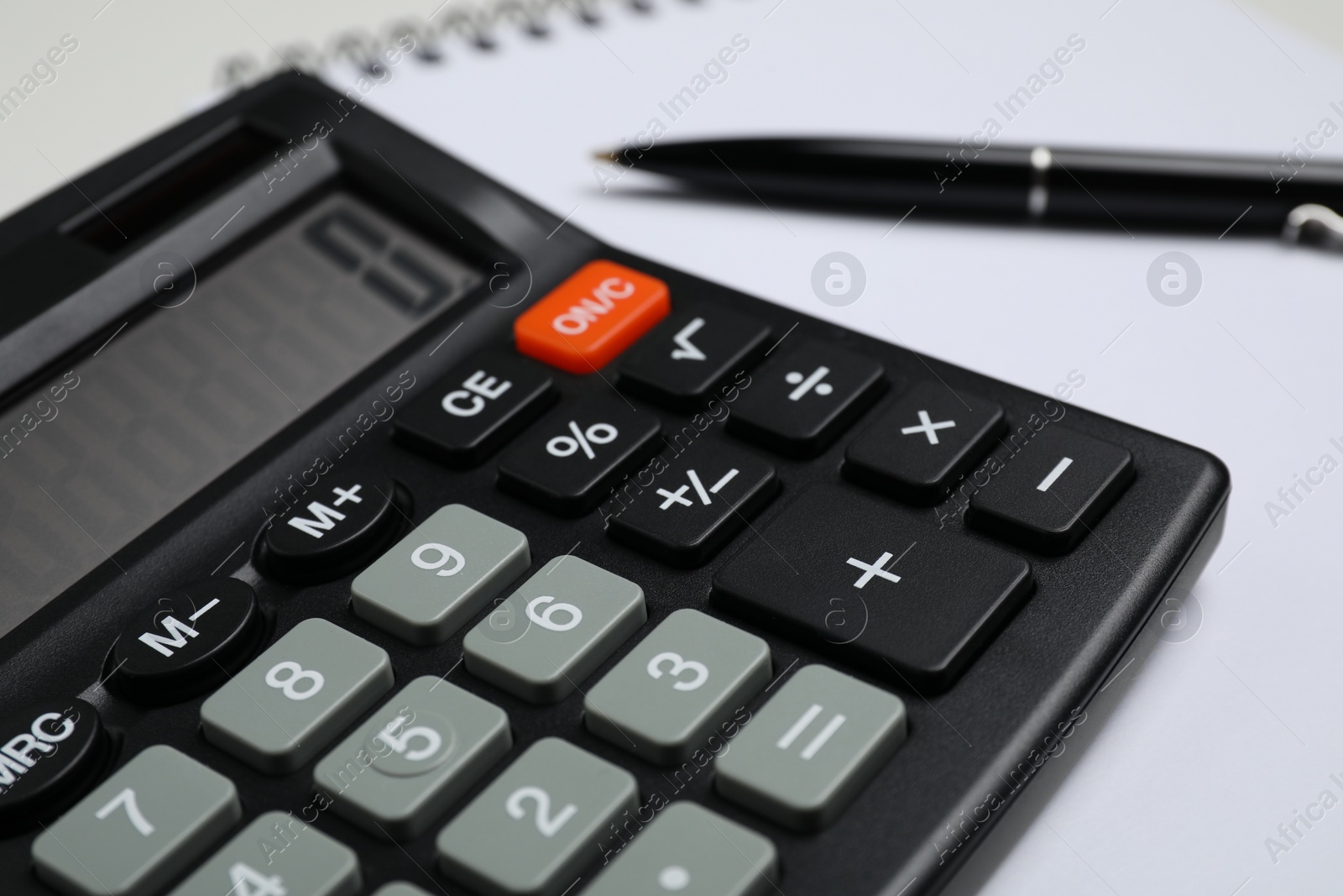 Photo of Calculator, pen and notebook on table, closeup