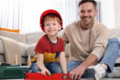 Photo of Father and son with bubble level at home. Repair work