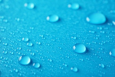Photo of Many clean water drops on color background